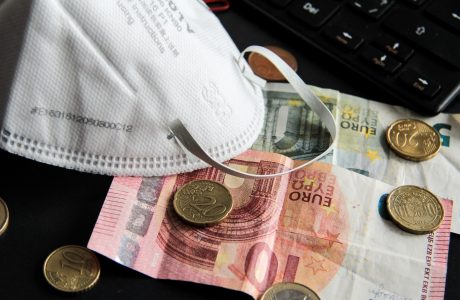 Euro notes and coins and a protective mask