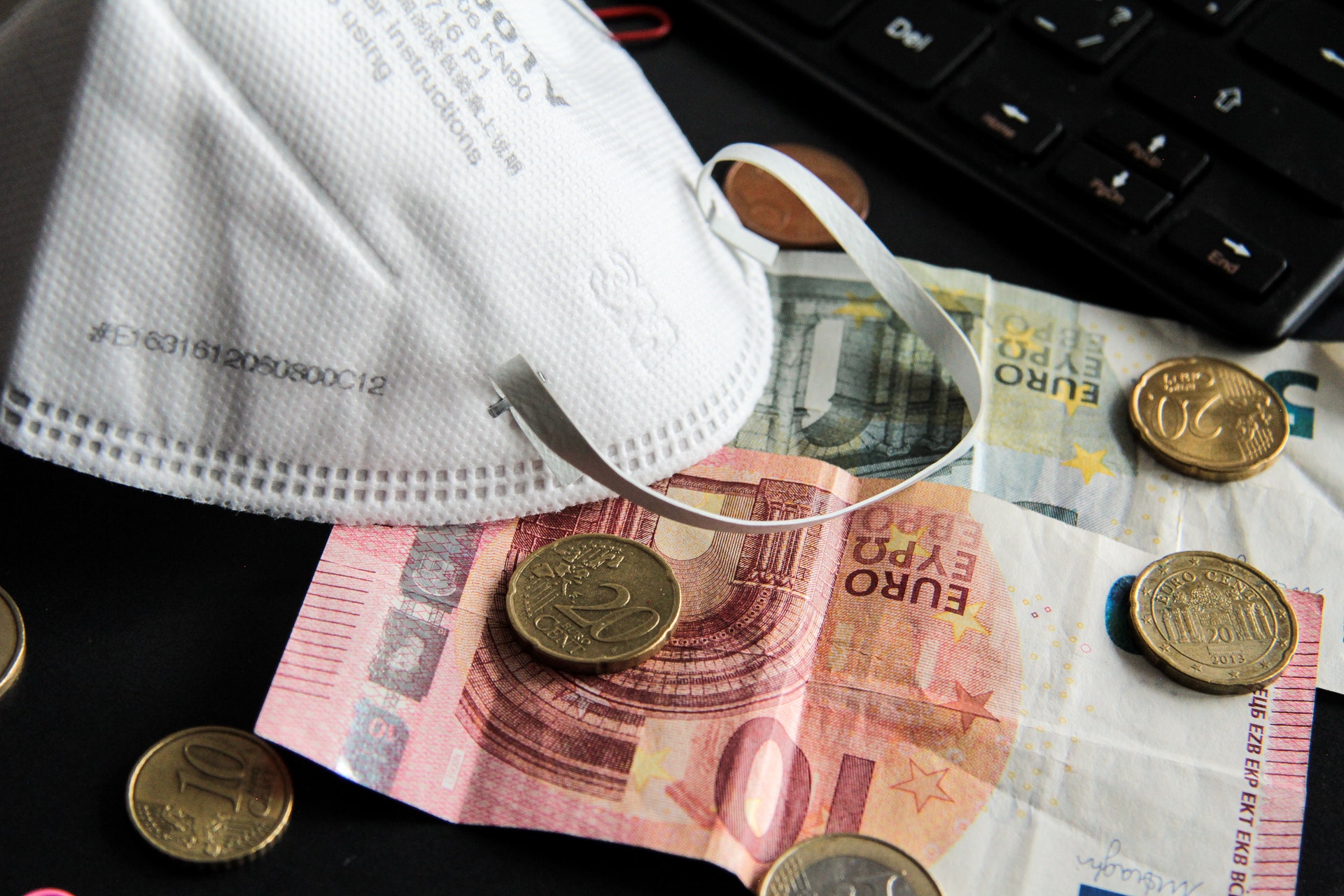 Euro notes and coins and a protective mask